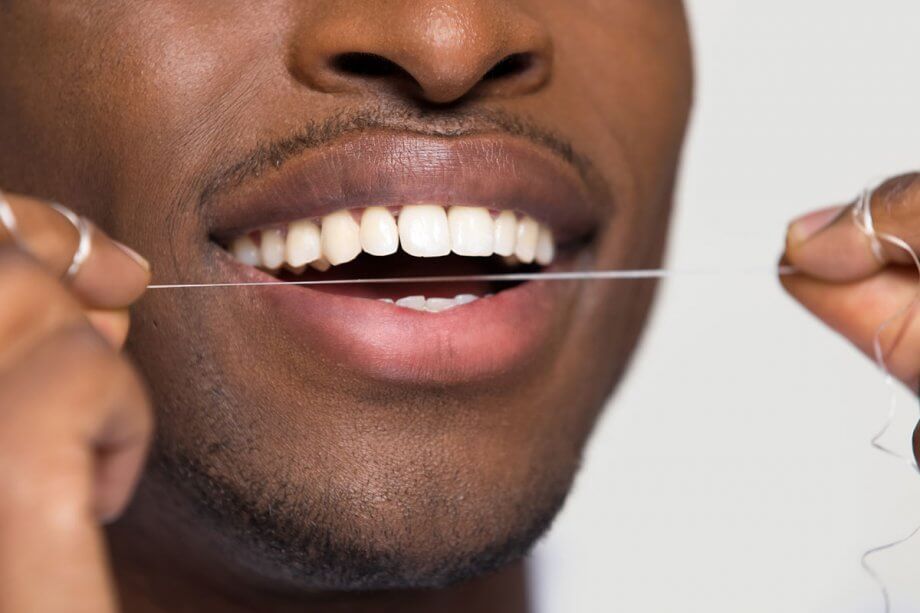 close up of man flossing teeth