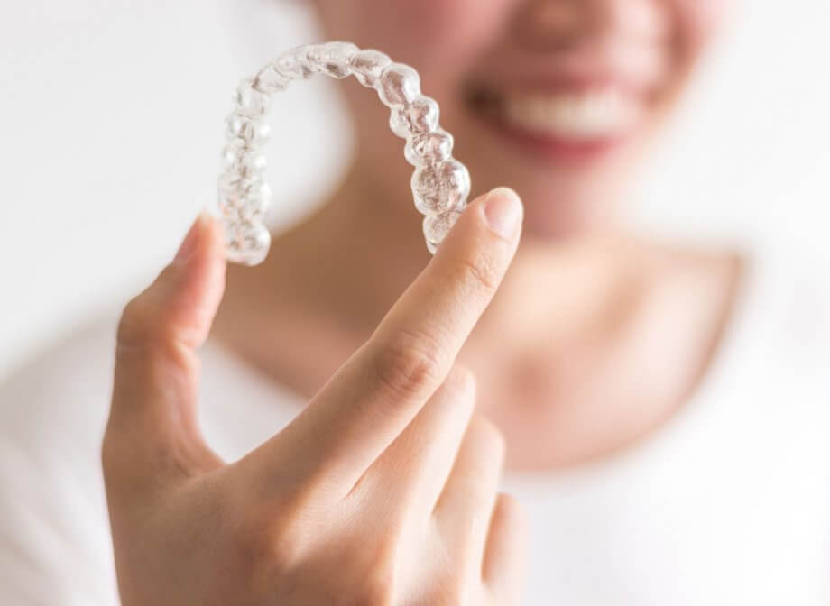 woman holding invisalign aligner