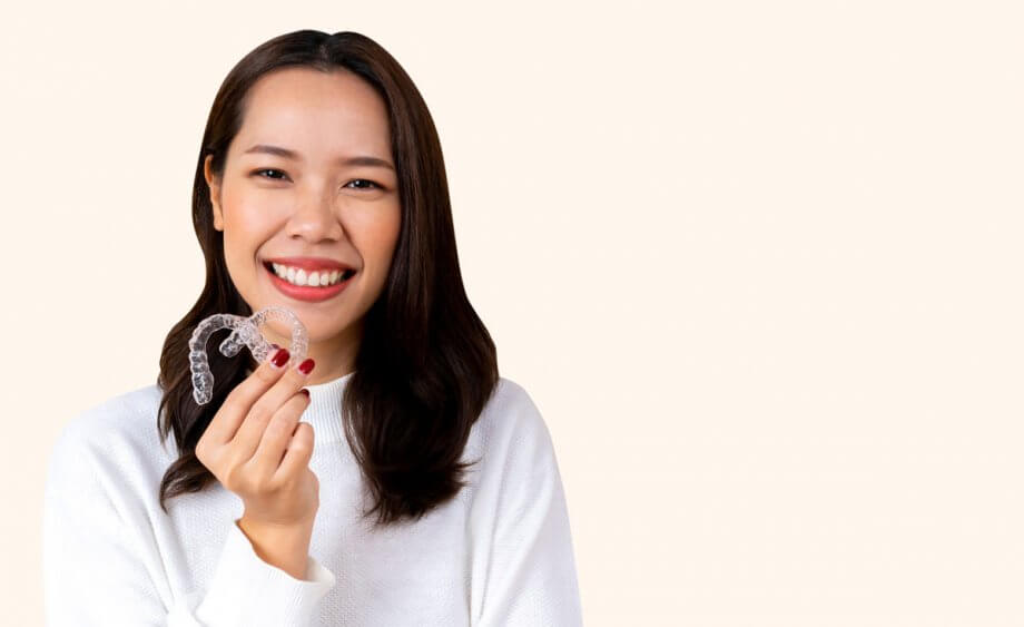 young woman holding invisalign aligners